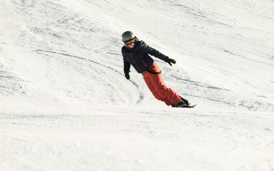 Frau fährt in Südtirol Snowboard